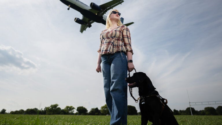 Elizabeth Schoen with her black Labrador service dog, Eva, at Gravelly Point Park near Reagan National Airport in Arlington, Va.
