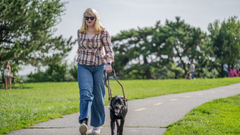 Service dog Eva guides Elizabeth Schoen along a trail at Gravelly Point Park.