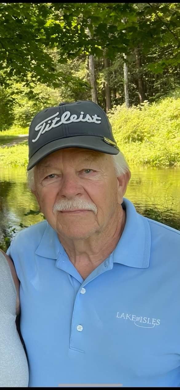 A picture of a man wearing a gray hat that says "Titleist" and a light blue polo shirt.