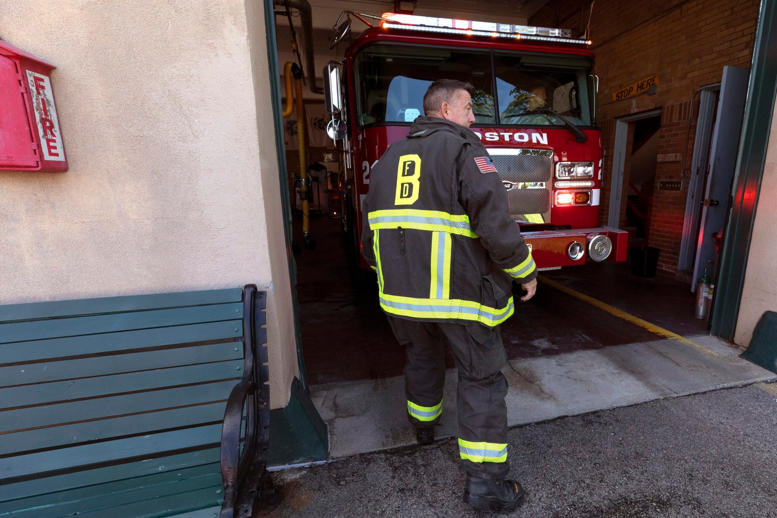 Firefighter Rod MacKinnon wears his turnout gear as he enters the Engine 21 fire station in Dorchester. 