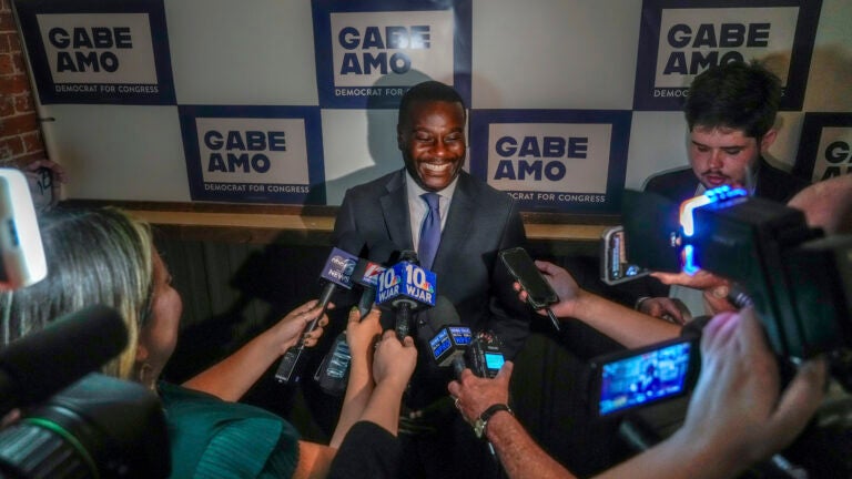 Gabe Amo meets with members of the press at an election results party.