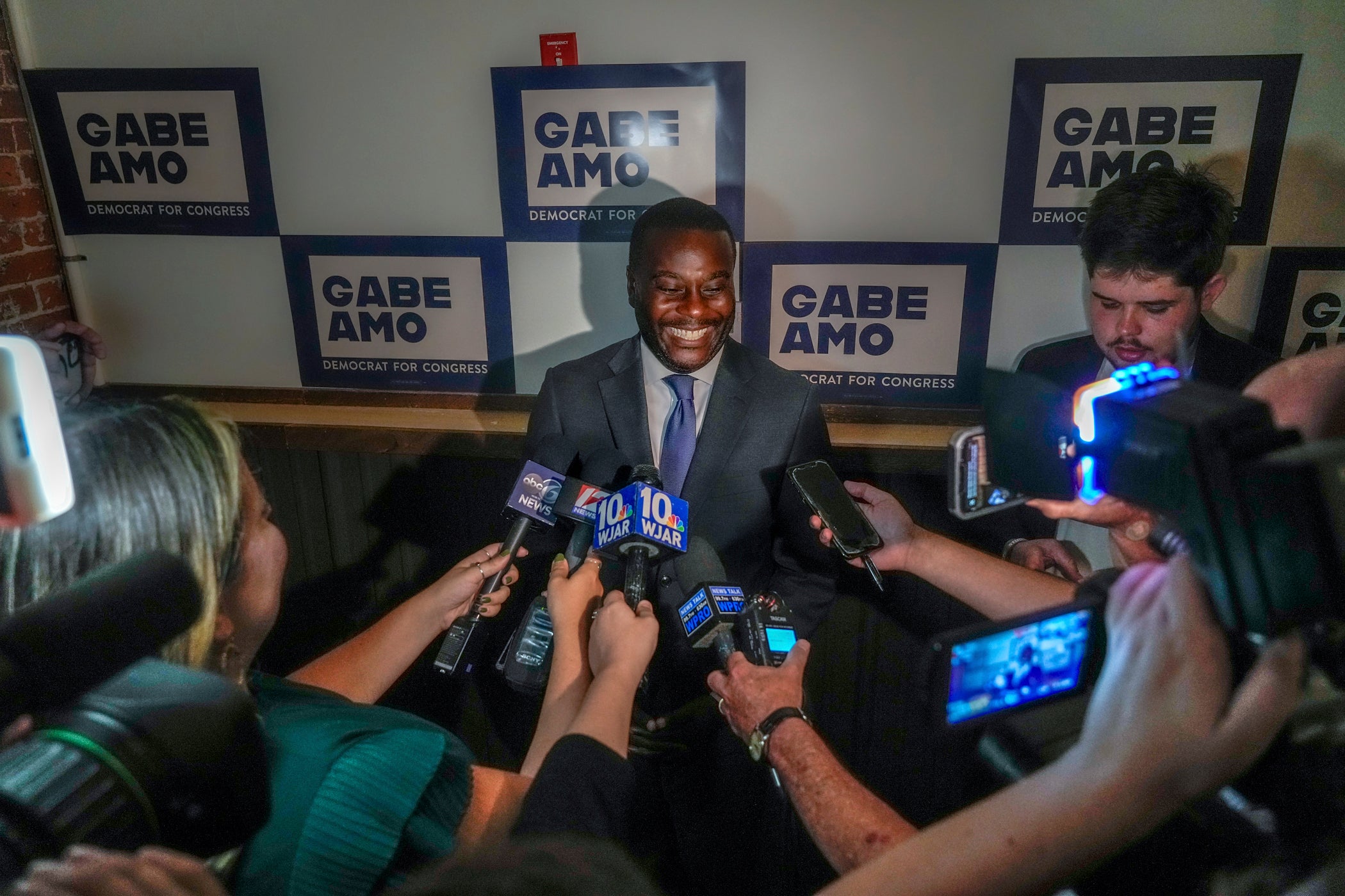 Gabe Amo meets with members of the press at an election results party.
