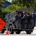 Law enforcement officers ride by a roadblock.