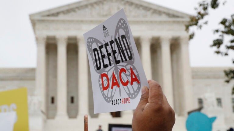 Someone holds up a "Defend DACA" sign during a rally in front of the Supreme Court in Washington.