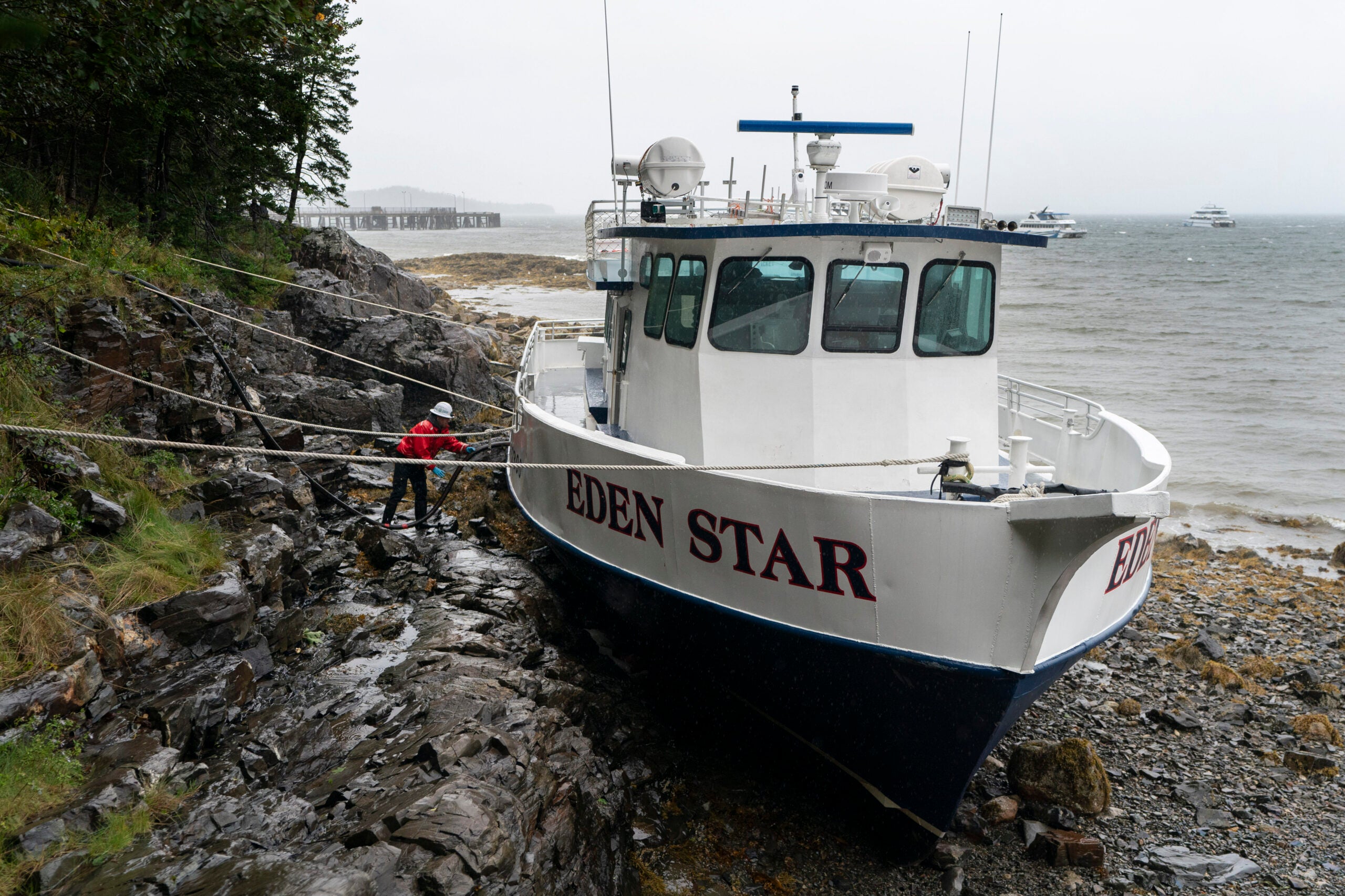 A worker prepares to unload diesel fuel from the Eden Star, a 70-foot tour boat that broke free of its mooring during storm Lee.