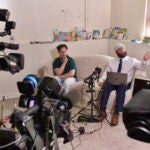 Adnan Syed presents evidence of alleged prosecutorial misconduct during a media conference at his family's home as his younger brother Yusuf Syed listens.