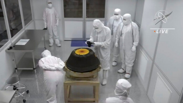 Technicians in a clean room examine the sample return capsule from NASA's Osiris-Rex mission.