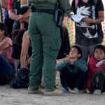 Migrants who crossed into the U.S. from Mexico wait to be processed by U.S. Border Patrol agents in Eagle Pass, Texas.