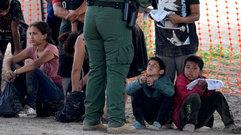 Migrants who crossed into the U.S. from Mexico wait to be processed by U.S. Border Patrol agents in Eagle Pass, Texas.
