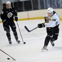 Defenseman Mason Lohrei, right fires a shot on goal during a Bruins development camp scrimmage at Warrior Arena.