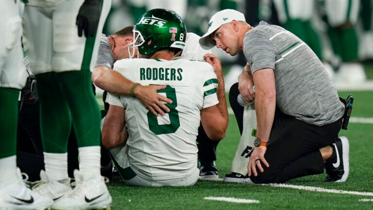 New York Jets quarterback Aaron Rodgers (8) is tended to on the field during the first quarter.