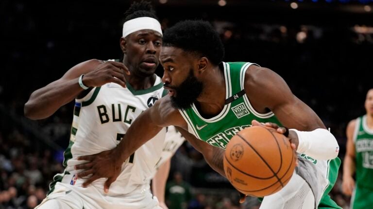 Boston Celtics' Jaylen Brown tries to get past Milwaukee Bucks' Jrue Holiday during the second half of an NBA basketball game Thursday, April 7, 2022, in Milwaukee. The Bucks won 127-121.