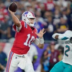 New England Patriots quarterback Mac Jones (10) throws a pass while pressured by Miami Dolphins linebacker Bradley Chubb (2) during the first half an NFL football game, Sunday, Sept. 17, 2023, in Foxborough, Mass.
