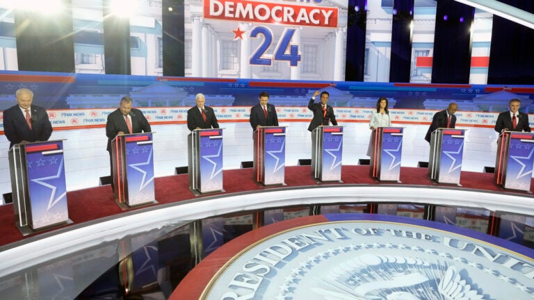 Republican presidential candidates stand on stage before a Republican presidential primary debate.