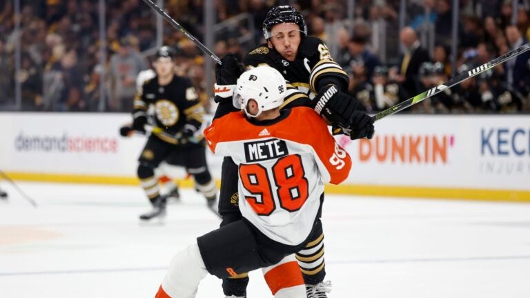 Boston Bruins' Brad Marchand (63) checks Philadelphia Flyers' Victor Mete (98) during the first period of a preseason NHL hockey game Friday, Sept. 29, 2023, in Boston.