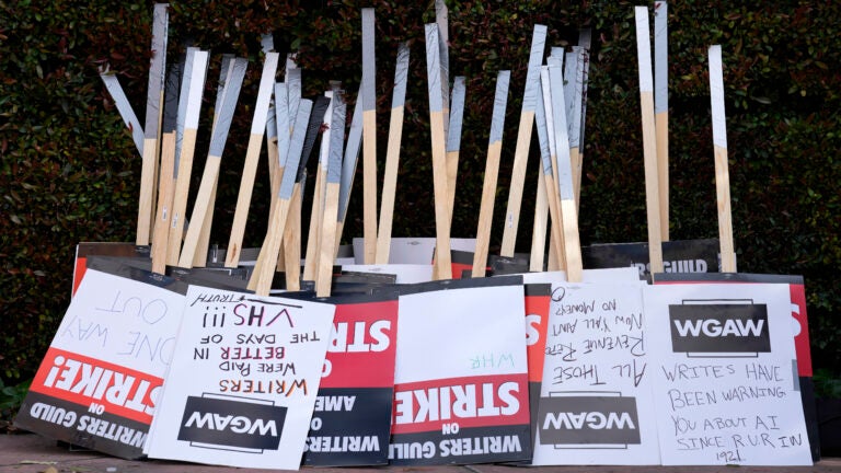 Placards are gathered together at the close of a picket.