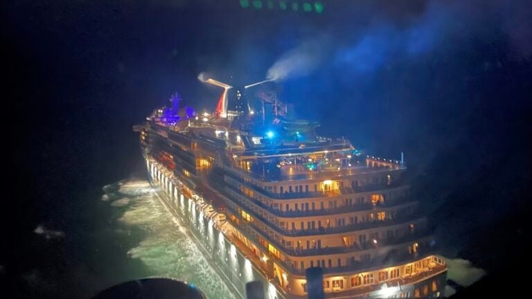 A photo of a Carnival Legend cruise ship on water at night.