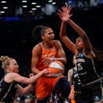 Connecticut Sun forward Alyssa Thomas, center, drives to basket against New York Liberty forward Jonquel Jones.
