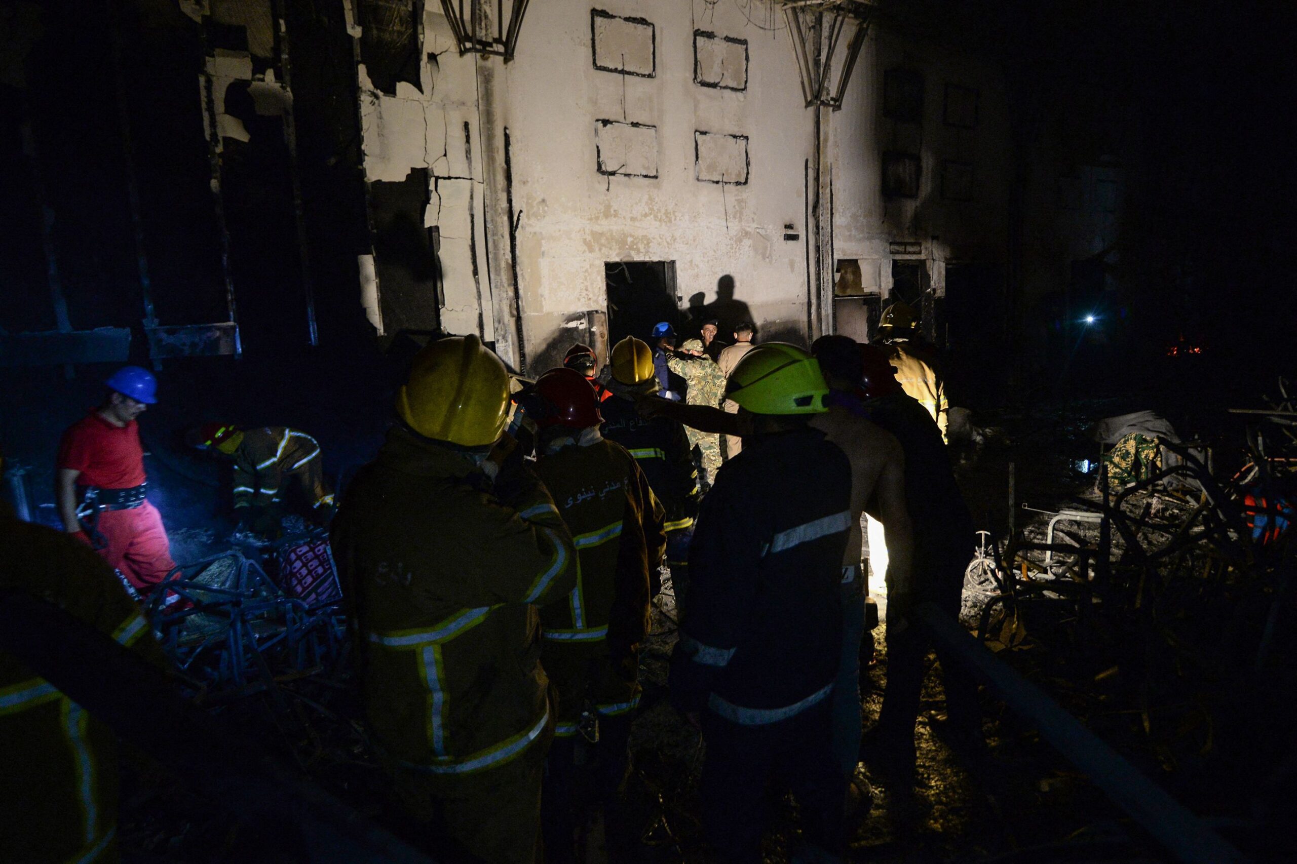 Civil defense members inspect the scene of a fire that broke out during a wedding at an event hall in Al-Hamdaniyah, Iraq on September 27, 2023.