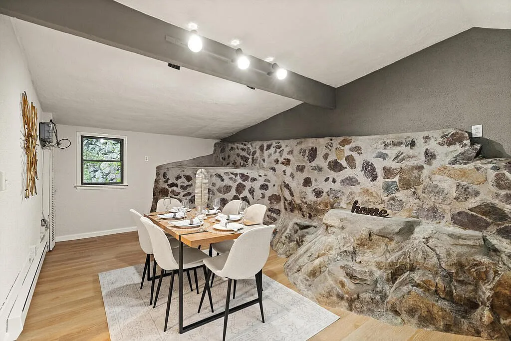 Dining room in Malden home for sale, with rock structure. 