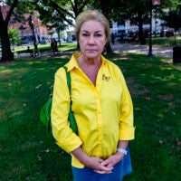 Deb Libby, wearing a yellow button up shirt, poses in Worcester, Mass.