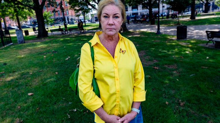 Deb Libby, wearing a yellow button up shirt, poses in Worcester, Mass.