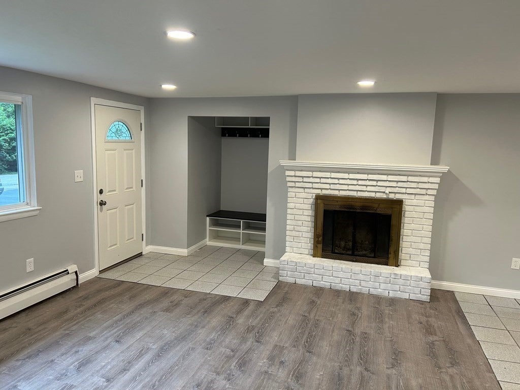 Living space in Maynard home with white brick fireplace. 