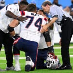 New England Patriots offensive tackle Riley Reiff (74) is tended to after being hurt during an NFL preseason football game against the Tennessee Titans Saturday, Aug. 26, 2023, in Nashville, Tenn.