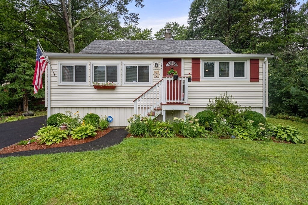 Plainville home with red front door, American flag, and landscaping. 