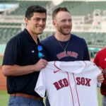 New Boston Red Sox shortstop Trevor Story, center, holds a jersey as manager Alex Cora, right, and Chief Baseball Officer Chaim Bloom, left, join in during a baseball press conference at JetBlue Park Wednesday, March 23, 2022, in Fort Myers, Fla.