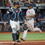 Rafael Devers of the Red Sox scores behind Rays catcher Christian Bethancourt during the fourth inning.
