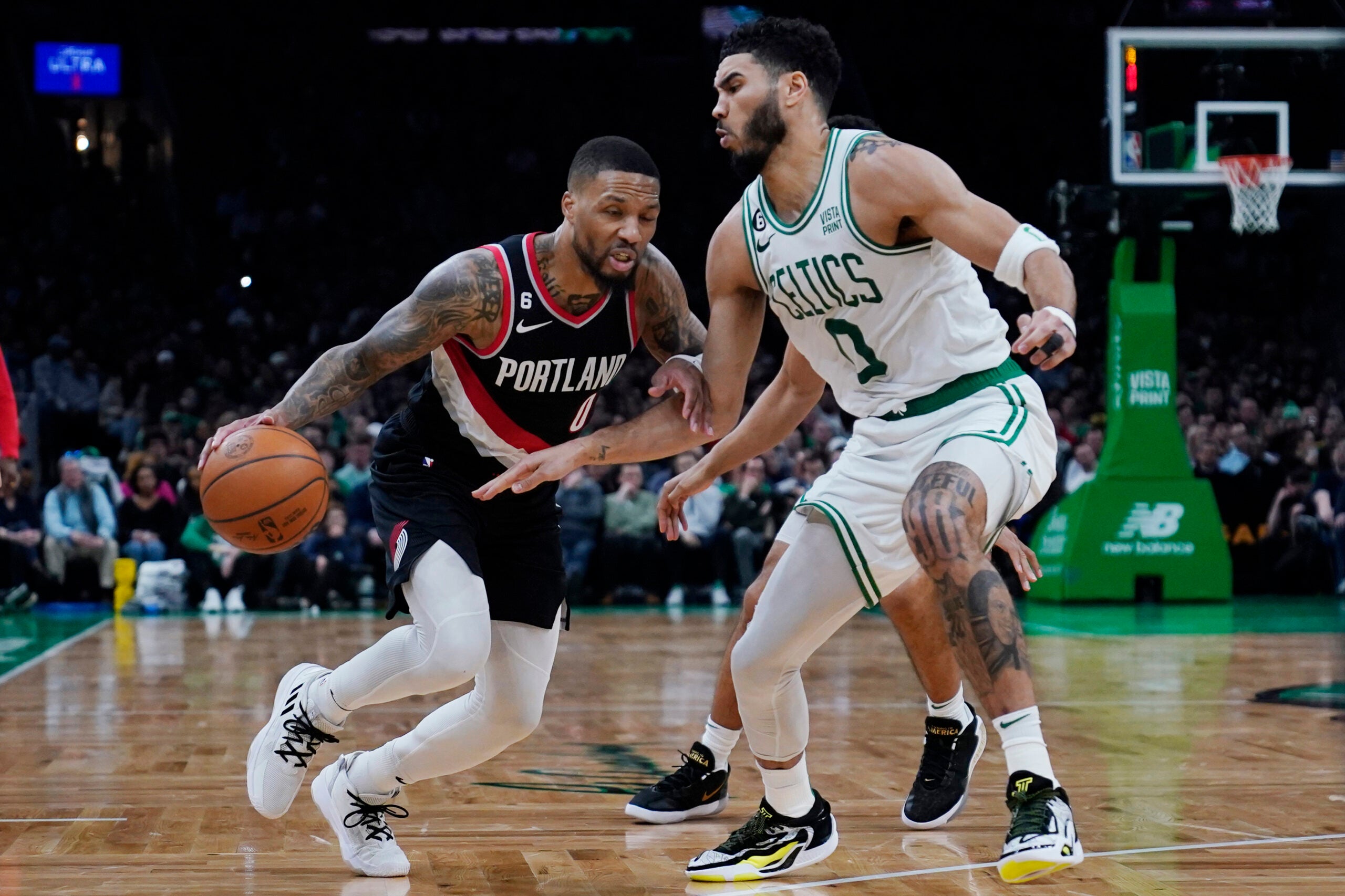 Damian Lillard drives to the basket against Jayson Tatum during a March 8, 2023 game in Boston.