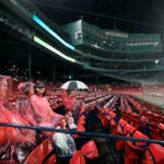 Fans wore ponchos in the stands during a rain delay at Fenway Park Wednesday.
