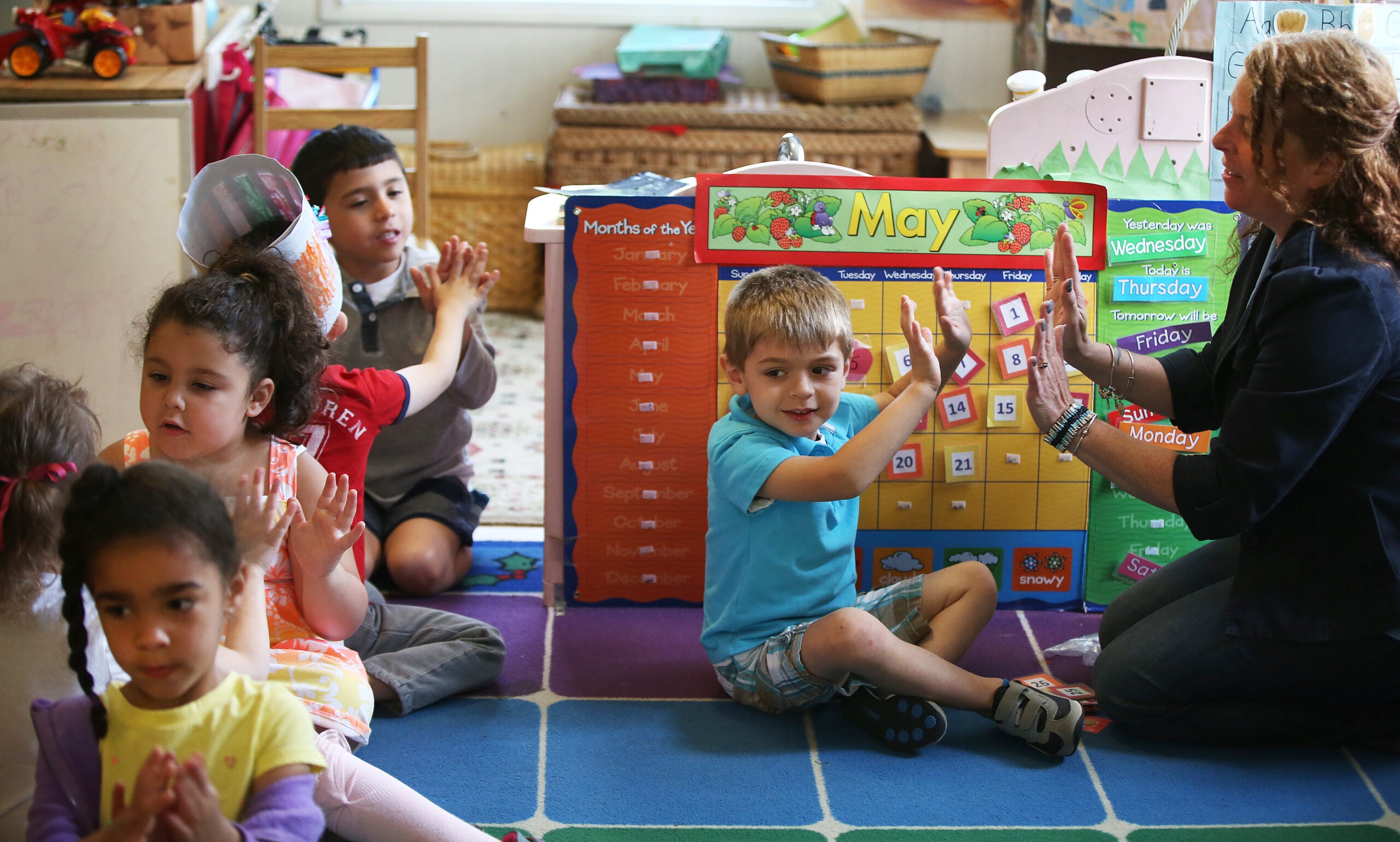 Jameson Pilling (cq), 3, claps with teacher Kerrelle Dow (cq). Little Discoveries provides child care in Brockton. A classroom with 3- to 5-year-olds is photographed, on Thursday, May 21, 2015.