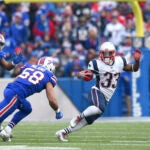 New England Patriots running back Dion Lewis (33) runs with the ball as Buffalo Bills outside linebacker Matt Milano (58) moves in for the tackle during the first half of an NFL football game, Sunday, Dec. 3, 2017, in Orchard Park, N.Y. Patriots' Rob Gronkowski (87) applies a block on Bills' Jerry Hughes (55) on the play.