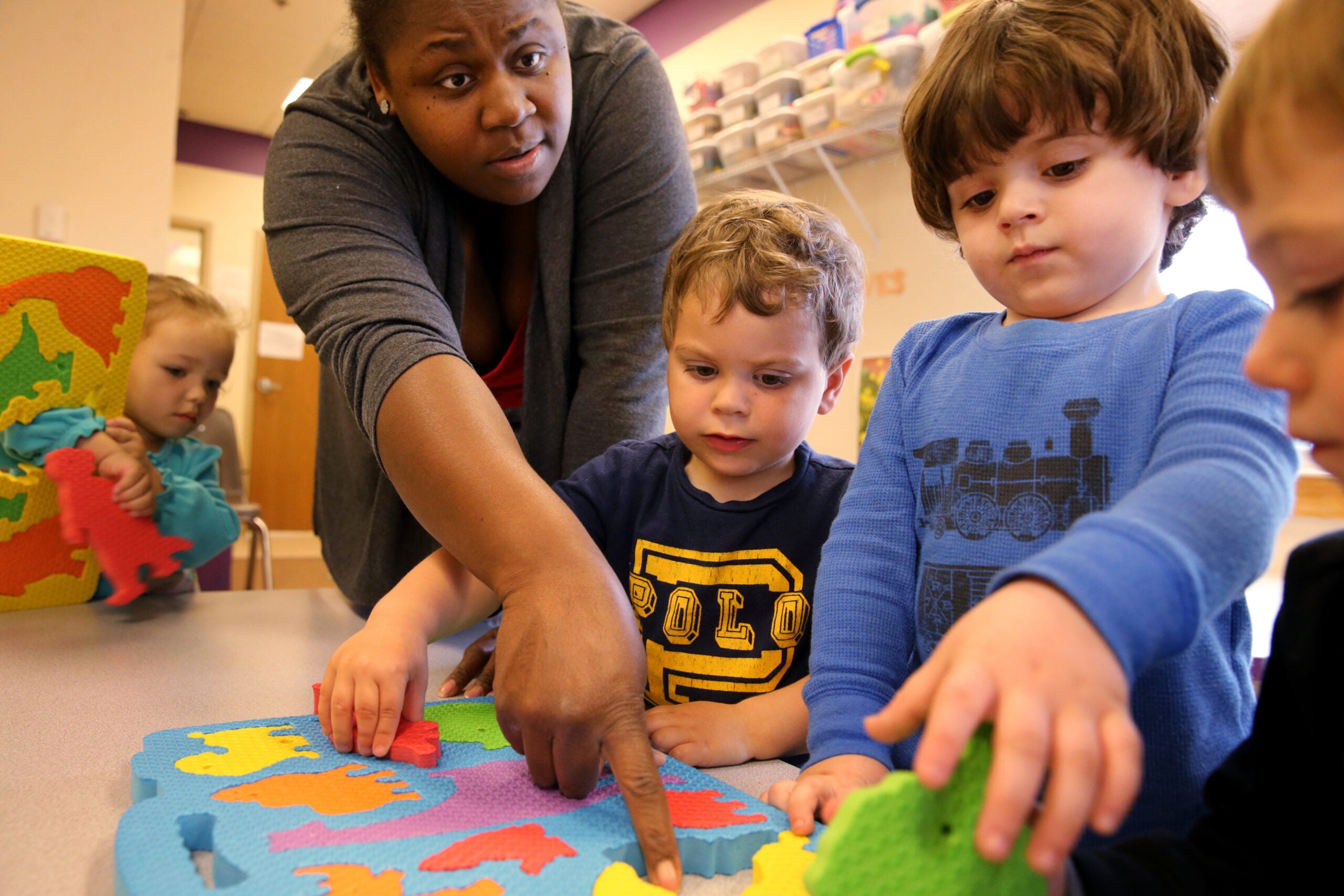Teacher Latonya Hazard works on puzzles with students (left to right) Lilyana Waire, 2, Jordan Conrad, 2, Caiden Groccia, 2, and Joshua Davis, 2, at the Guild of St. Agnes in Worcester, MA on April 25, 2017.
