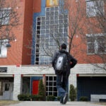 A man walks on a community college campus.