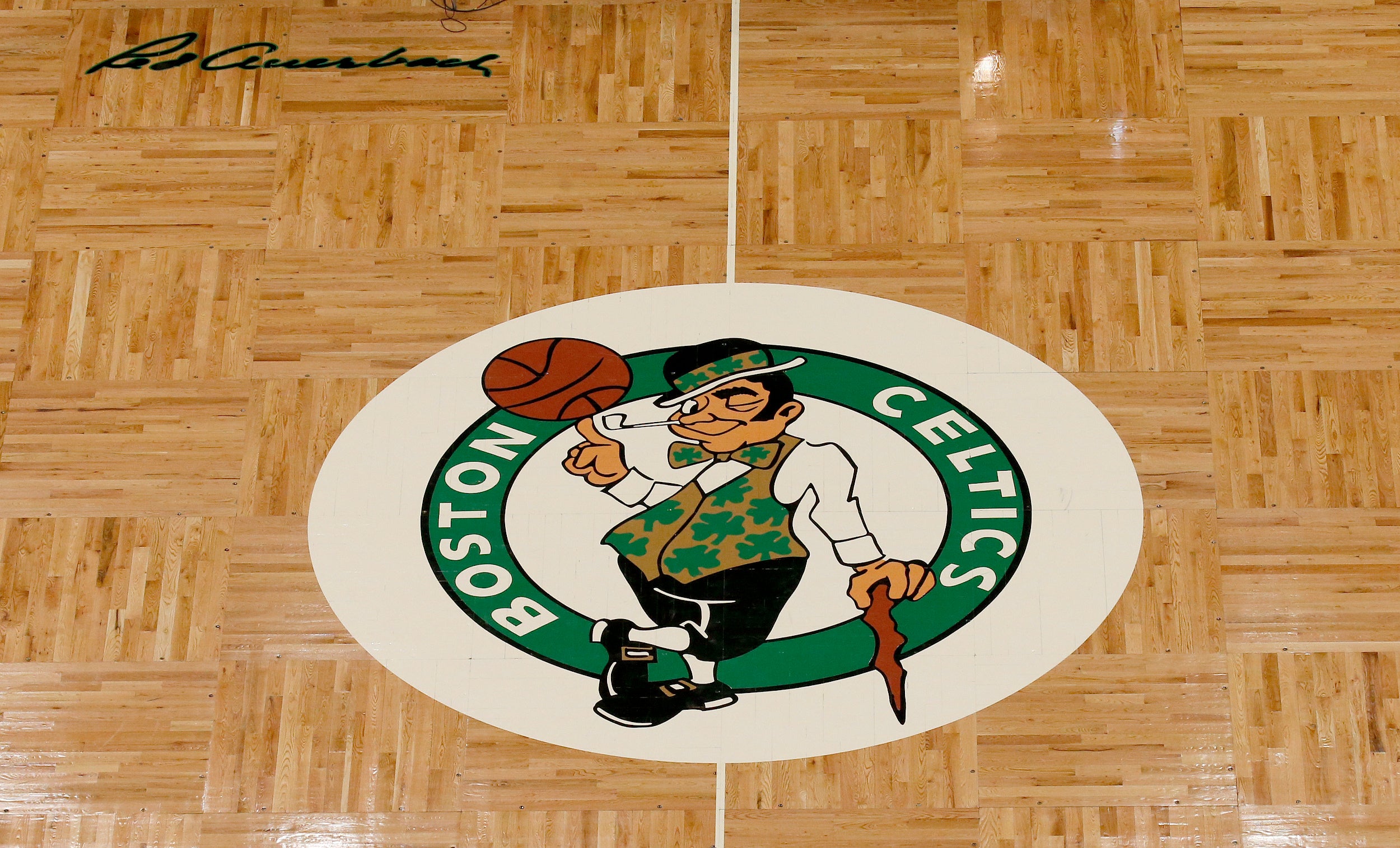 The Boston Celtics logo and Red Auerbach signature are seen on the TD Garden parquet floor before the start of an NBA basketball game, Wednesday, Feb. 27, 2019, in Boston.