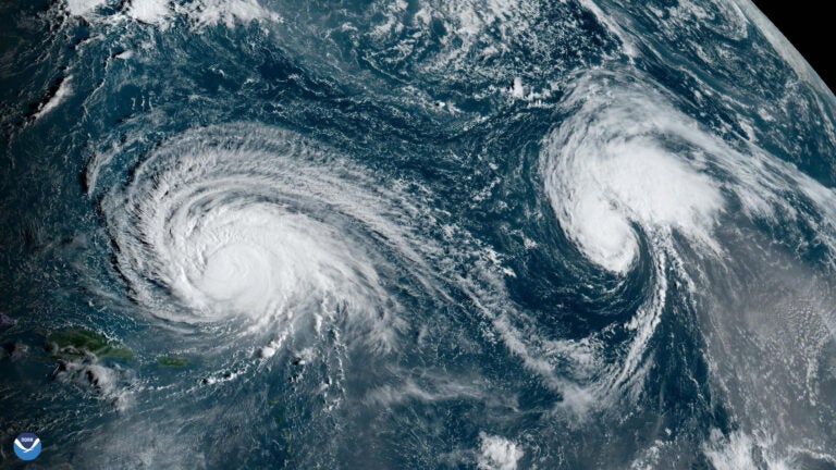 A satellite Hurricane Lee to the left and Hurricane Margot to the right in the Atlantic Ocean.