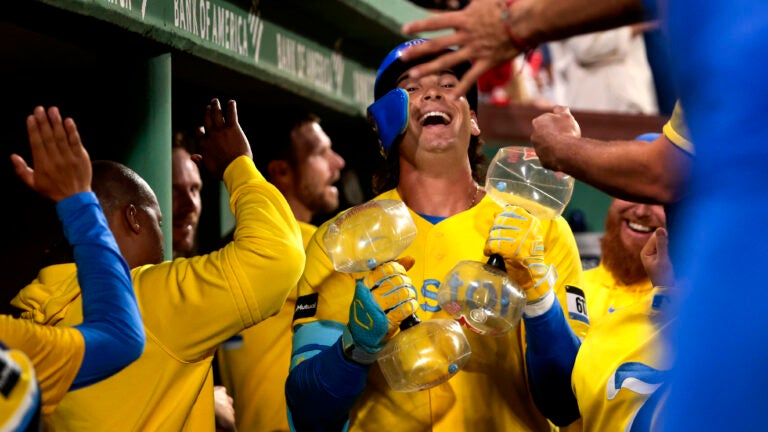 In yellow jerseys, players celebrate as one laughs toward the sky.