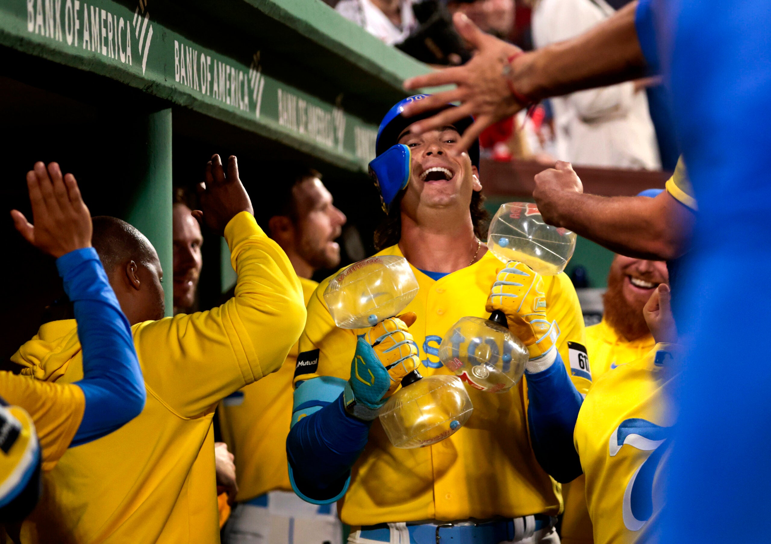 In yellow jerseys, players celebrate as one laughs toward the sky.