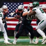 New England Patriots quarterback Mac Jones (10) hands off to New England Patriots running back Ezekiel Elliott (15) with better line blocking for the run during the third quarter. The New York Jets host the New England Patriots at MetLife Stadium in East Rutherford, NJ Sunday, September 24, 2023.