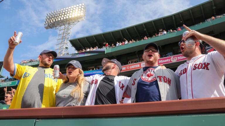 Fans in the front row at Fenway Park sing 'Sweet Caroline.'