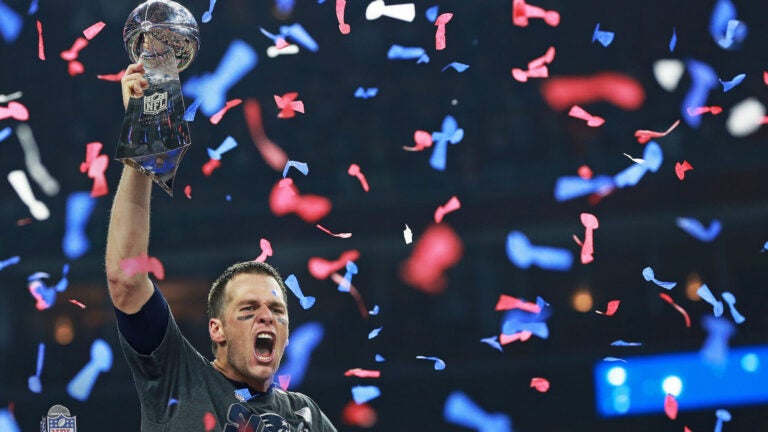 As confetti falls around him, Patriots quartetrback Tom Brady howls as he hoists the Vince Lombardi Trophy following New England's come from behind victory. The Atlanta Falcons play the New England Patriots in Super Bowl LI at NRG Stadium in Houston on Feb 5.