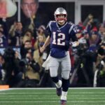 Foxborough MA: 01-04-20: Some giant signs are in the backround as Patriots quarterback Tom Brady (12) was the center of attention as he did his usual pre game scream to the fans before he headed back in the other direction to get in some pre game throwing. The New England Patriots hosted the Tennessee Titans in an AFC Wildcard Playoff game at Gillette Stadium.