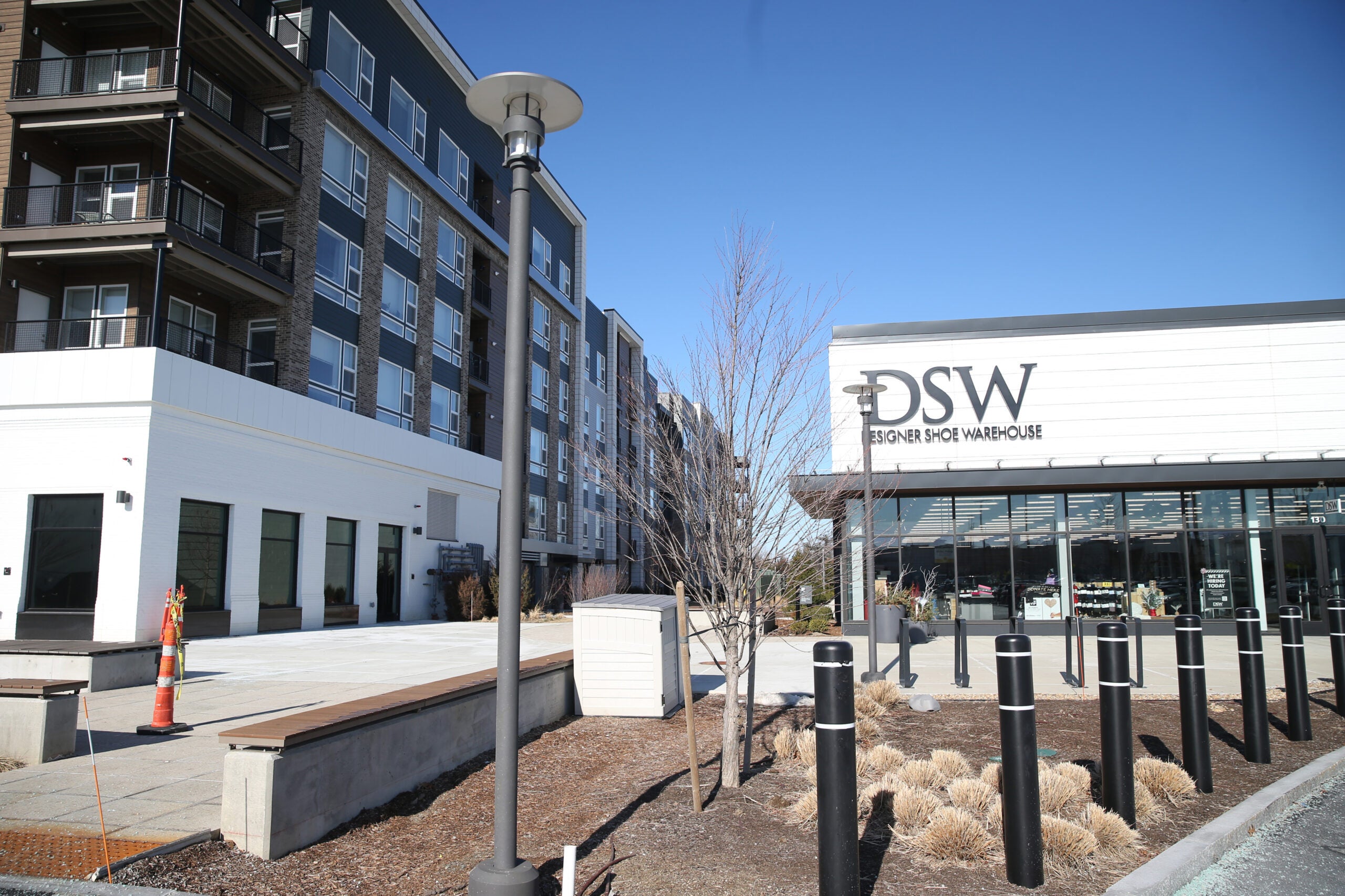 a view of a four-story apartment building next to a DSW shoe store.