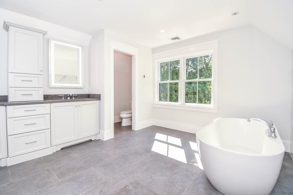 Bathroom with gray tile flooring, and white finishes. 