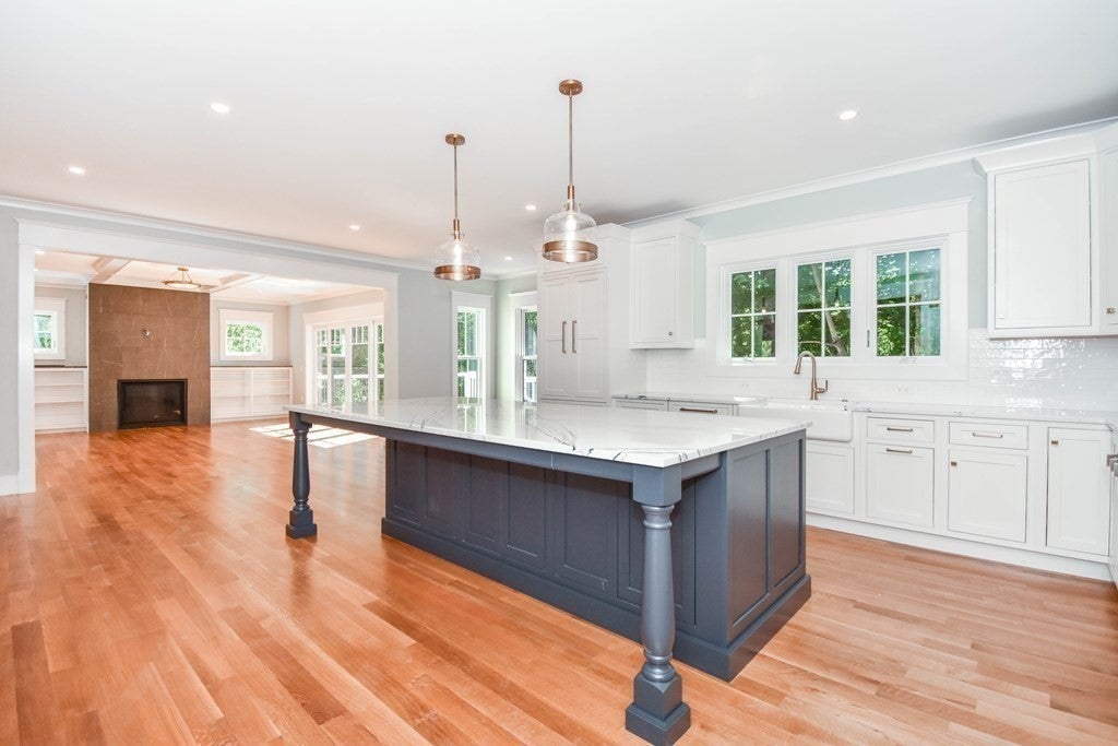 Kitchen with island and white cabinets in Weston home. 