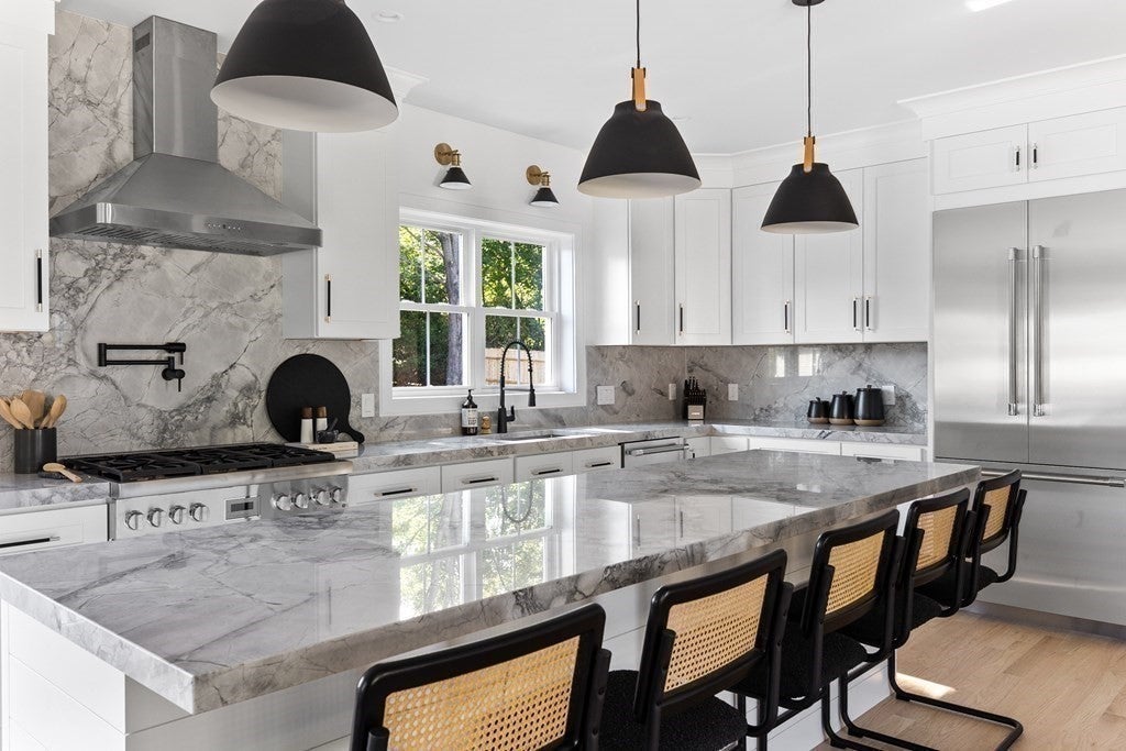 Modern kitchen with white cabinets in Woburn home. 