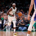 Boston Celtics guard Jrue Holiday (4) dribbles the ball up the court.